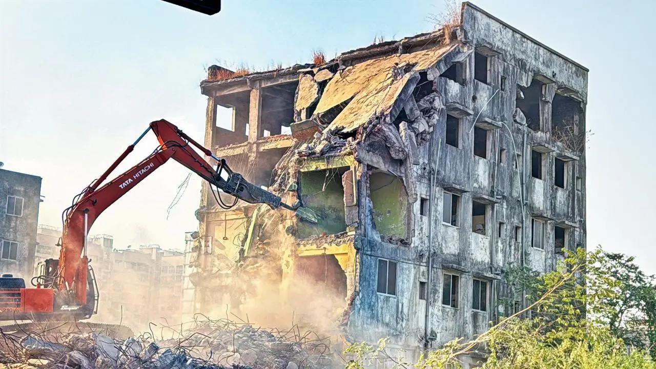 پیمانکاران در حال تخریب ساختمان با تجهیزات ایمنی کامل